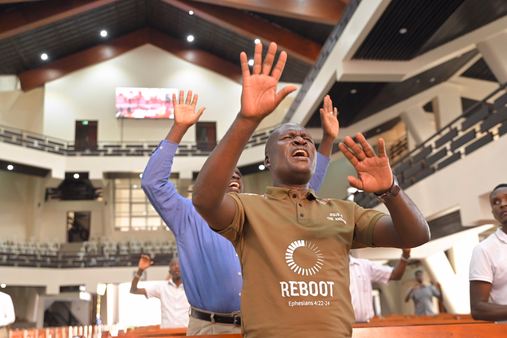 A man lifting his hands in worship at All Saints’ Cathedral